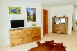 ein Wohnzimmer mit einem TV auf einer Holzkommode in der Unterkunft Chesa Auricula - a80609 in Pontresina