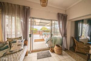 a living room with a bed and a sliding glass door at Bella@Jbay in Jeffreys Bay