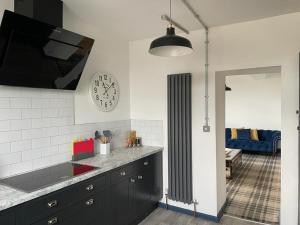 una cocina con fregadero y un reloj en la pared en The Beulah Apartments, en Leeds
