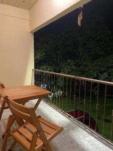 d'une table en bois et d'une chaise sur un balcon. dans l'établissement Pousada Boa Vista, à Cachoeiras de Macacu