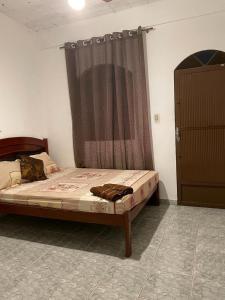 a bed sitting in a room with a curtain at Pousada Boa Vista in Cachoeiras de Macacu