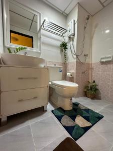 a bathroom with a toilet and a sink and a mirror at 66 Apartment in Ban Khlong Nong Yai