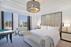 a bedroom with a bed and a desk and a chair at The St. Regis Amman in Amman
