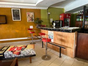 a restaurant with a bar with stools and a counter at Rozala Motel in Bondo