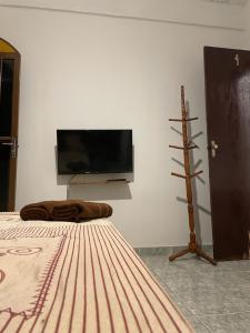 1 dormitorio con 1 cama y TV en la pared en Pousada Boa Vista, en Cachoeiras de Macacu