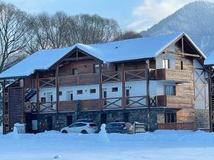 ein Blockhaus im Schnee mit vor der Tür geparkt in der Unterkunft Ski & Sun B9 in Liptovský Mikuláš