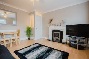 a living room with a fireplace and a flat screen tv at Hullidays - Hymers Apartment in Hull