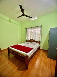 a bedroom with a bed with a ceiling fan at Casita Riverside Villas in Vythiri