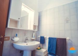 bagno con lavandino e specchio di Casa Mameli Apartment Villasimius a Villasimius