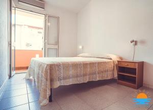 a bedroom with a bed with a table and a window at Casa Mameli Apartment Villasimius in Villasimius