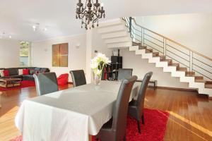 une salle à manger avec une table, des chaises et un escalier dans l'établissement Madeira Villa Liliana, à Campanário