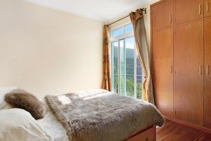 a bedroom with a bed and a large window at Madeira Villa Liliana in Campanário
