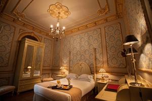 a bedroom with a bed and a chandelier at Hotel Rural OLIVENZA PALACIO in Olivenza