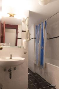 a bathroom with a sink and a mirror and a tub at MC Hotel in Žalec