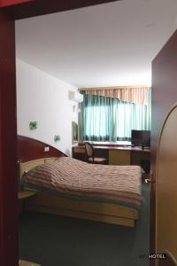 - une chambre avec un lit, un bureau et une fenêtre dans l'établissement MC Hotel, à Žalec