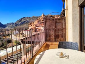 uma mesa numa varanda com vista para uma montanha em Aparthotel SPA Don Iñigo de Aragón em Las Cuevas de Cañart