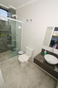 y baño con aseo, lavabo y ducha. en Pousada Castelo do Rei en Penha