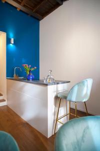eine Bar mit zwei Stühlen und einer blauen Wand in der Unterkunft Palazzetto de Lante Appartamento Parione in Rom