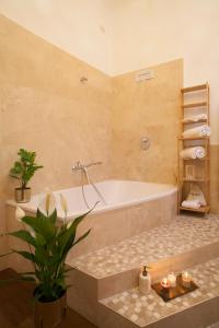 ein Badezimmer mit einer Badewanne und einer Topfpflanze in der Unterkunft Palazzetto de Lante Appartamento Parione in Rom