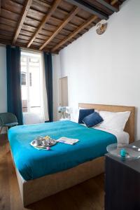 ein Schlafzimmer mit einem großen Bett mit einer blauen Decke in der Unterkunft Palazzetto de Lante Appartamento Parione in Rom