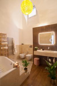 a bathroom with a tub and a sink and a mirror at Palazzetto de Lante Appartamento Parione in Rome