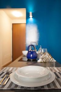 eine weiße Platte auf einem Tisch mit blauer Wand in der Unterkunft Palazzetto de Lante Appartamento Parione in Rom