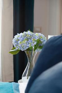 eine Vase voller blauer Blumen auf einem Tisch in der Unterkunft Palazzetto de Lante Appartamento Parione in Rom