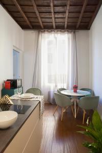 a kitchen with a table and chairs in a room at Palazzetto de Lante Appartamento Parione in Rome