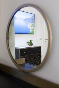 a mirror reflecting a dresser with a tv on a wall at Palazzetto de Lante Appartamento Parione in Rome +13 photos