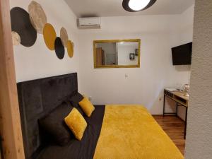 a bedroom with a large bed with a yellow blanket at Rooms Argo in Cres