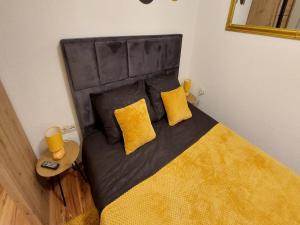 um quarto com uma cama com almofadas amarelas em Rooms Argo em Cres