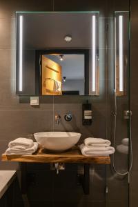 a bathroom with a sink and a glass shower at Vesting Hotel Naarden in Naarden