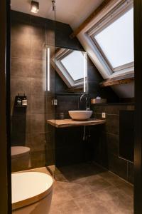 a bathroom with a sink and a skylight at Vesting Hotel Naarden in Naarden