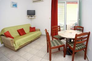 a living room with a couch and a table with chairs at Apartments & Rooms Villa Petra in Zaboric