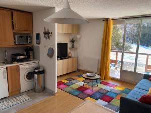 - une cuisine et un salon avec un tapis coloré dans l'établissement APPARTEMENT RÉNOVE, RÉSIDENCE COTE BRUNE, CENTRE STATION, PIED DES PISTES, 30m² 4/5 pers, à Les Deux Alpes