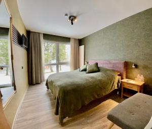 ein Schlafzimmer mit einem Bett und einem großen Fenster in der Unterkunft Berghotel Hohegeiß in Hohegeiß
