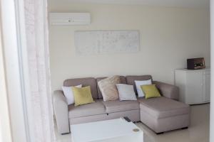 uma sala de estar com um sofá e uma mesa em Eucalyptus - The Apartment em Olhos de Água