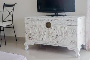 a white dresser with a television on top of it at Eucalyptus - The Apartment in Olhos de Água