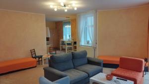 a living room with a blue couch and a living room with a table at Apartmán v centru Jihlavy in Jihlava