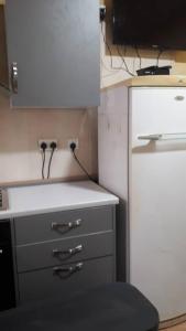 a kitchen with a white counter and a white refrigerator at DAN'S PLACE in Accra