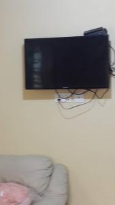 a flat screen tv hanging on a wall next to a couch at DAN'S PLACE in Accra