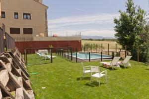 un patio con sillas, una piscina y un edificio en Miradiez Segovia en Espirdo