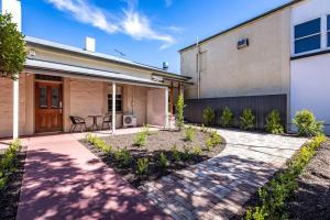 a home with a patio and a building at Tanunda Central Apartment in Tanunda
