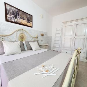 una camera da letto con un grande letto bianco con due spade bianche di Agriturismo La Rondine a Otranto