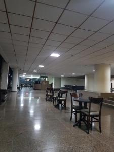an empty waiting area with tables and chairs in an airport at hotel gold beach in Recife
