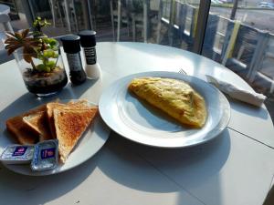 a table with two plates of food and toast at The Hampton Exclusive Guesthouse in East London