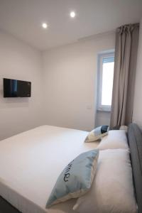 a large white bed with two pillows and a window at [Chiaia] Arcoleo House - Sofia in Naples