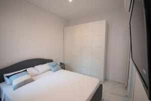 a bedroom with a white bed with blue and white pillows at [Chiaia] Arcoleo House - Sofia in Naples