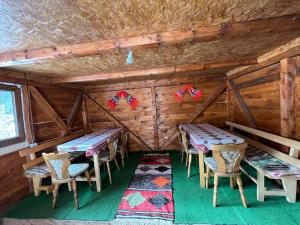 a room with tables and chairs in a cabin at Cabana Sânziana in Gîrda de Sus
