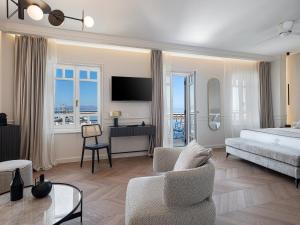 1 dormitorio con 1 cama y escritorio con TV en Riviera Suites en La Canea